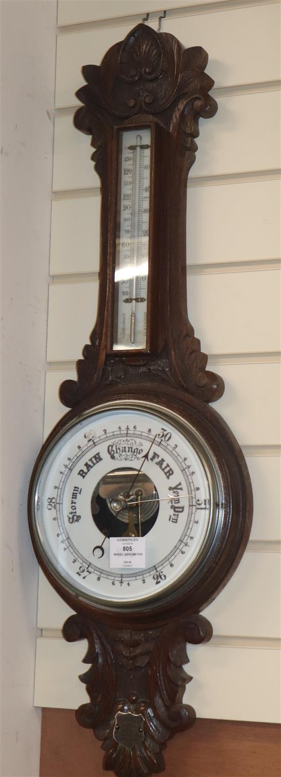 An Edwardian carved oak wheel barometer, by Scargill H.83cm